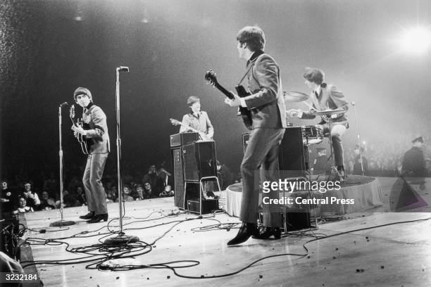 The Beatles in performance at the Washington Coliseum. Left to right : George Harrison , Paul McCartney, John Lennon and Ringo Starr.