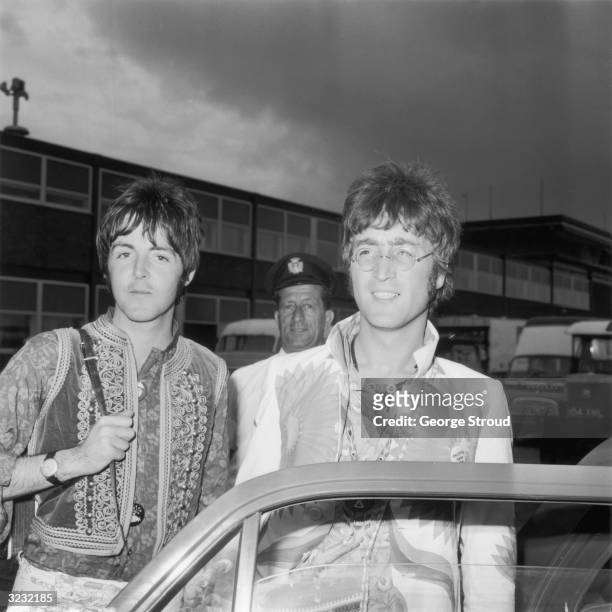 John Lennon and Paul McCartney of the Beatles arrive at London Airport after a trip to Greece.