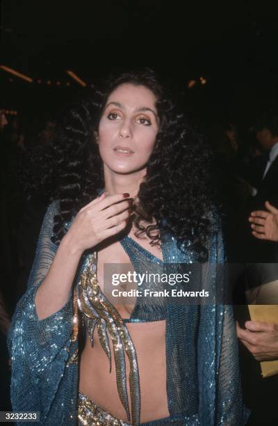 American actor and singer Cher stands and holds her hand up to her throat at the opening of 'Filmex' at the LA Film Festival, California. Cher wears...
