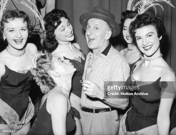 American actor and comedian Jimmy Durante smiling among a group of five dancers in a promotional portrait for the television show 'Texaco Star...