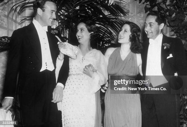 Actors David Niven , Merle Oberon , Norma Shearer , and her husband, producer Irving Thalberg , smiling with their arms around one another at Mayfair...