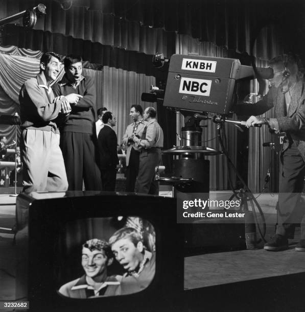 American comic team Jerry Lewis and Dean Martin performing for the camera on the set of the television show, 'Hollywood vs TV'. A group of men stand...