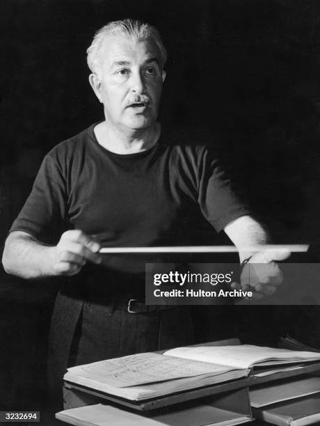 American classical conductor Arthur Fiedler raises his baton as he conducts the Boston Pops Orchestra for a weekly radio broadcast at Symphony Hall,...