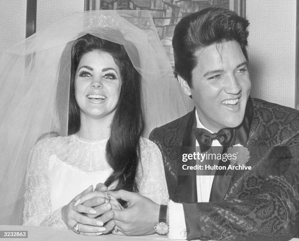 Rock and roll singer and actor Elvis Presley holding hands with his bride, Priscilla Beaulieu Presley, on their wedding day, Las Vegas, Nevada.