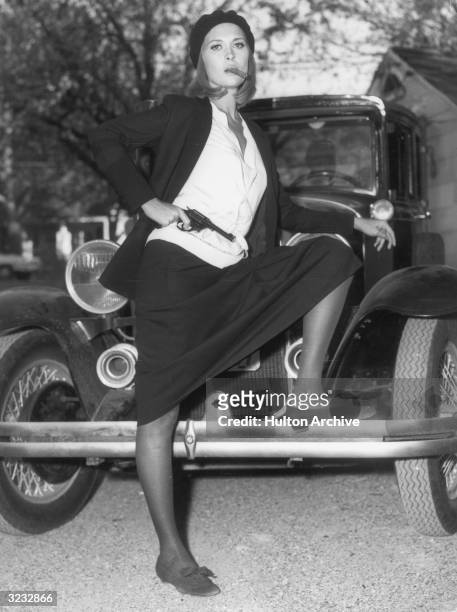 American actor Faye Dunaway as bank robber Bonnie Parker in a still from director Arthur Penn's film, 'Bonnie and Clyde'. She is posing with her foot...