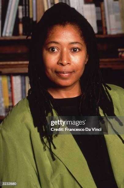 American author Alice Walker posing in front of a bookcase.