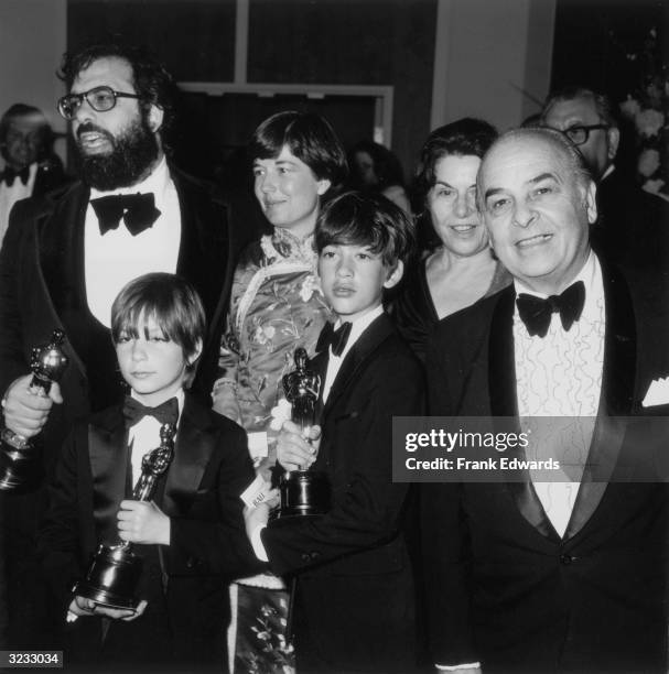 American film director Francis Ford Coppola stands with his family, holding three Oscars for his film, 'The Godfather, Part II,' during the 47th...