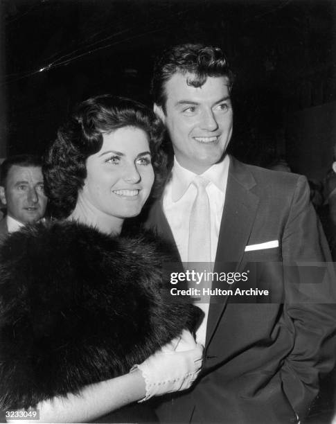 American actor William Campbell smiles with his wife Judith Exner Campbell as they attend the premiere of director Jesse Hibbs' film, 'To Hell and...