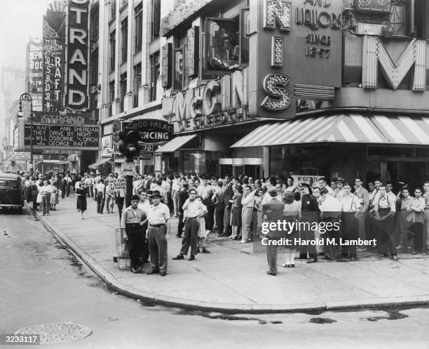 Moviegoers queue up around the block, outside the Stand Theater in Times Square, New York City. Director Raoul Walsh's film, 'They Drive By Night,'...