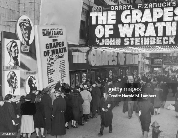 High-angle view of moviegoers waiting on line outside a theater where director John Ford's film, 'The Grapes Of Wrath' is advertised on the marquee,...