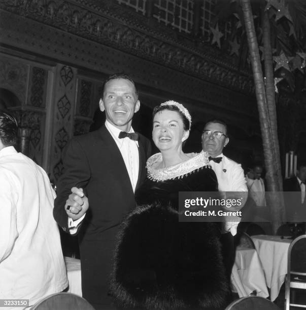 American actors and singers Frank Sinatra and Judy Garland smile together at the premiere of director George Cukor's film 'A Star Is Born,' in which...