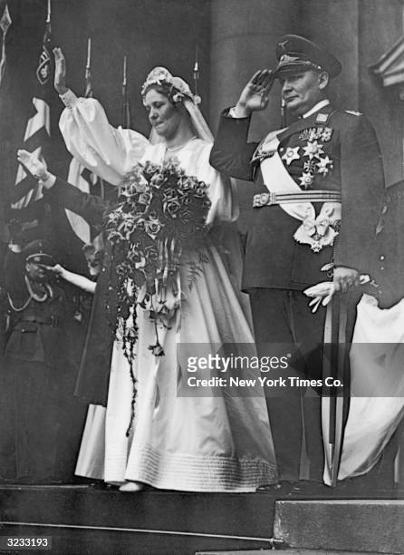 Prussian premier and Reich Air Minister Hermann Goering stands at attention while his bride, German actor Emmy Sonnemann , salutes on their wedding...