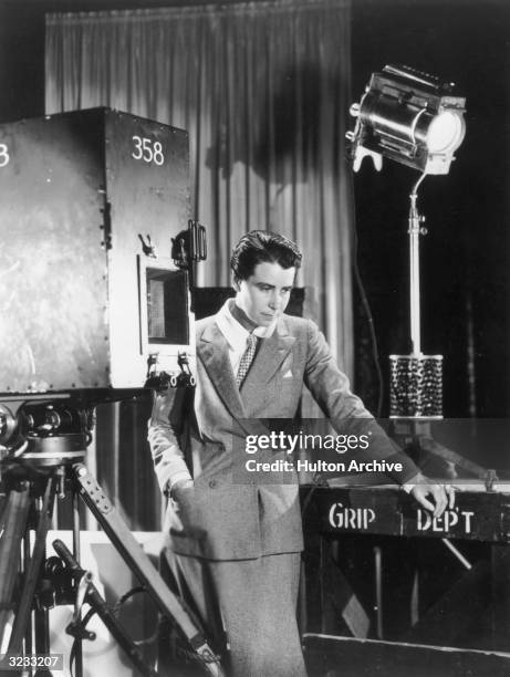 Portrait of American film director Dorothy Arzner standing among film equipment on a set at Paramount Studios, California. She is wearing a dress...