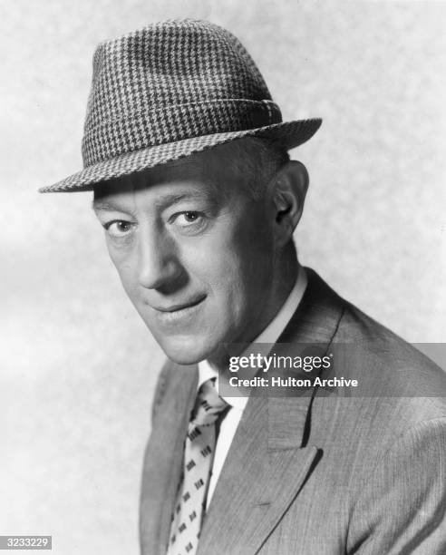 Headshot of British actor Alec Guinness , wearing a houndstooth hat, in a promotional portrait for director Mervyn Leroy's film, 'A Majority of One'.