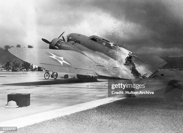 Damaged B-17C Flying Fortress bomber sits on the tarmac near Hangar Number 5 at Hickam Field, after the Japanese attack on Pearl Harbor, Hawaii.