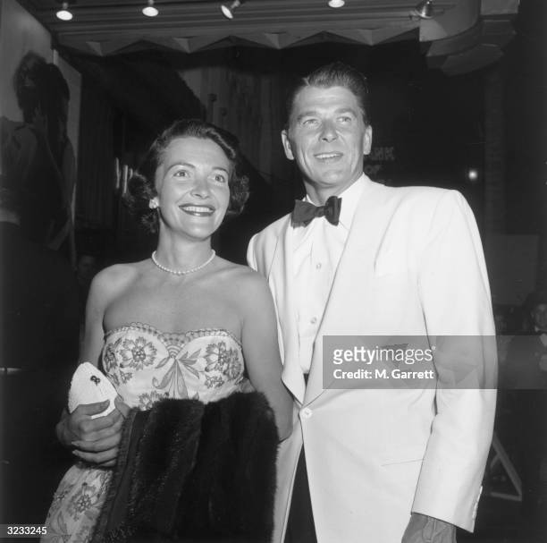 American actors Ronald Reagan and Nancy Davis standing together and smiling while at the premiere of director Elia Kazan's film, 'A Streetcar Named...