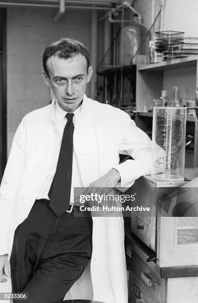 American biochemist Dr James Dewey Watson stands in his lab next to a model of the molecular structure of DNA.