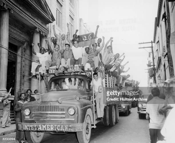 Trucks carry crowds celebrating the removal of dictator Fulgencio Batista and the arrival of Fidel Castro's 'July 26th Movement,' Havana, Cuba.