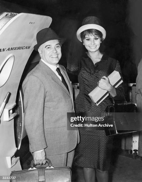 Italian producer Carlo Ponti and his wife, Italian actress Sophia Loren, depart for Rome to attend premieres of the film, 'Two Women,' for which she...