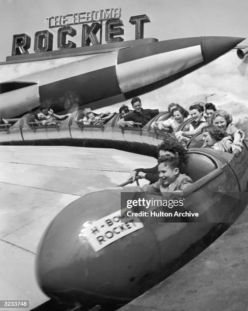 Children scream as they round a turn on the 'H-Bomb Rocket' ride at The Rockaways Playland amusement park, Rockaway Beach, Long Island, New York.