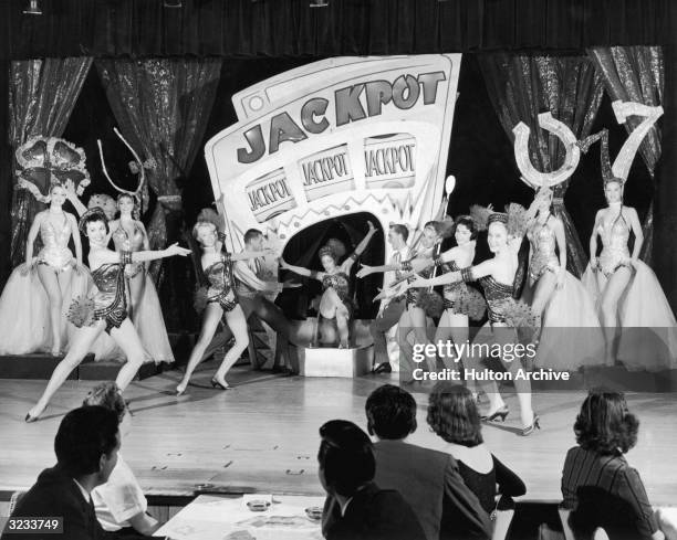 Showgirls dance for a production number in a 'Jackpot' show at a casino in Las Vegas, Nevada. Dancers in the background wear lucky symbols on their...