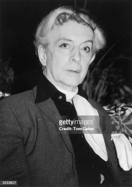 Headshot of British author Quentin Crisp at Freddy's Restaurant in New York City. He wears a light scarf.