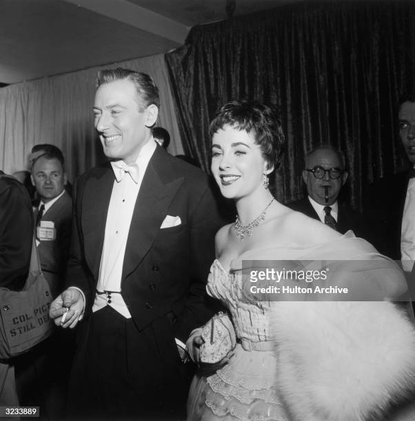 British-born actor Elizabeth Taylor smiles while walking with her second husband, British actor Michael Wilding , at the Academy Awards, Los Angeles,...