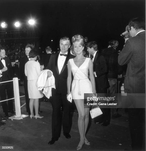Swedish-born actor Inger Stevens smiles with her unidentified date as they attend the 39th Annual Academy Awards, Santa Monica, California. She wears...