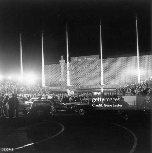 Exterior view of the Santa Monica Civic Auditorium at night, with crowds standing in bleachers during the 38th Annual Academy Awards, Santa Monica,...