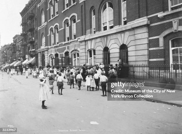 Children stand outside the Sherriff Street School at Stanton Street near Avenue D in the Lower East Side, New York City.