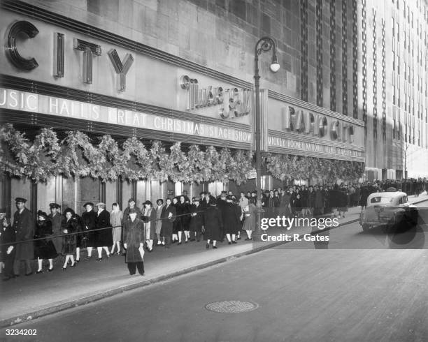 People queue outside Radio City Music Hall on 50th Street, Rockefeller Center, New York City. The Christmas Show and director Clarence Brown's film,...