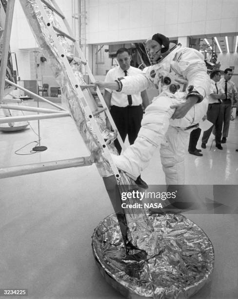 American astronaut Neil A Armstrong descends the ladder of a lunar module training vehicle during practice for an upcoming lunar landing mission,...