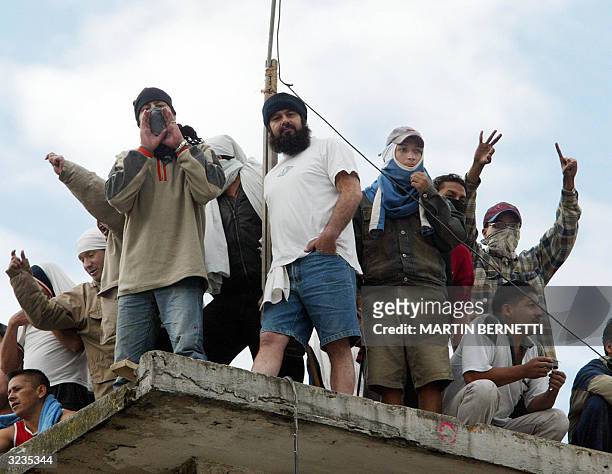 Mutineers standing atop the roof of the Garcia Moreno prison shout slogans 06 April, 2004 in Quito, Ecuador. Inmates in Quito prisons are holding 340...