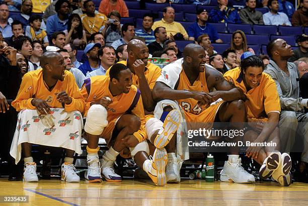 Gary Payton, Kobe Bryant, Karl Malone, Shaquille O'Neal and Rick Fox of the Los Angeles Lakers laugh as they sit on the bench during the game against...