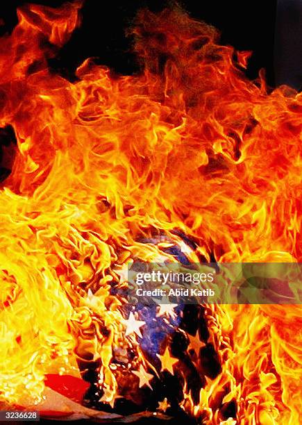 The U.S. Flag is seen as it is burned by angry Palestinian protesters, during a protest against the US policy in Iraq in front of the UN...