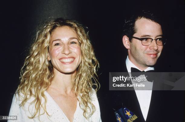 Married American actors Sarah Jessica Parker and Matthew Broderick smiling while standing in front of a handheld 'Access Hollywood' microphone at the...