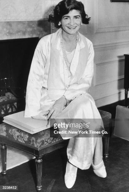 Portrait of French fashion designer Gabrielle 'Coco' Chanel posing in her suite at the Hotel Pierre during her first visit to New York City. She...