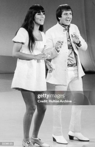 Full-length image of married American singers Cher and Sonny Bono of the pop duo Sonny and Cher performing on 'The Carol Burnett Show'. Sonny and...