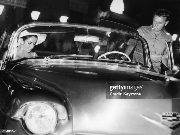 Film star couple Elizabeth Taylor and Richard Burton leave the Tre Scalini restaurant in Piazza Navona, Rome. She had just returned from a family...