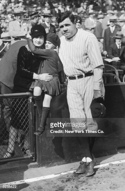 American baseball player for the Yankees Babe Ruth poses with his first wife Claire and their adopted daughter, Dorothy, on the sidelines before a...