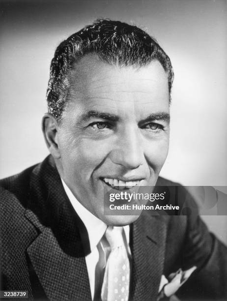 Headshot portrait of American variety show host Ed Sullivan as he smiles, circa 1965.