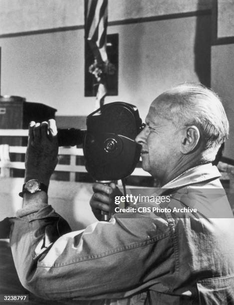 French photographer Henri Cartier-Bresson looks through the viewfinder of a movie camera on the set of the made-for-television film, 'California...