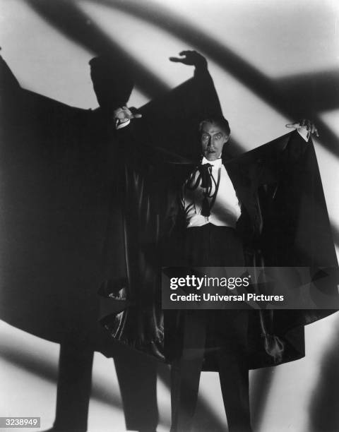 American actor John Carradine poses with his arms raised as Count Dracula in a promotional still for director Earle C Kenton's film, 'The House of...