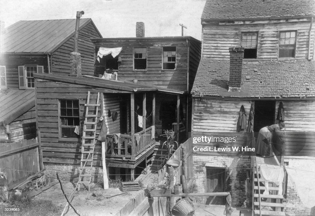 Poor Victorian Rookeries The back of tenement rookeries, with a woman standing on a narrow ...