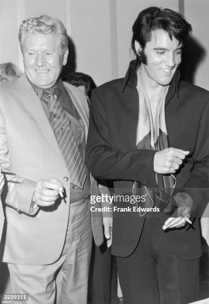 American singer and actor Elvis Presley and his father, Vernon Presley , laugh while attending a party hosted by singer and actor Frank Sinatra for...
