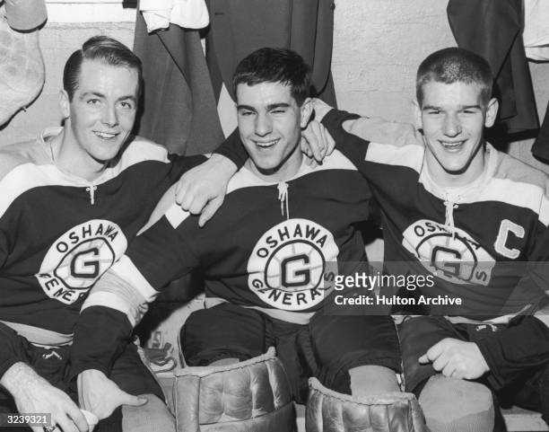 Canadian hockey player Bobby Orr poses with Oshawa Generals teammates Danny O'Shea and Ian Young in a locker room.