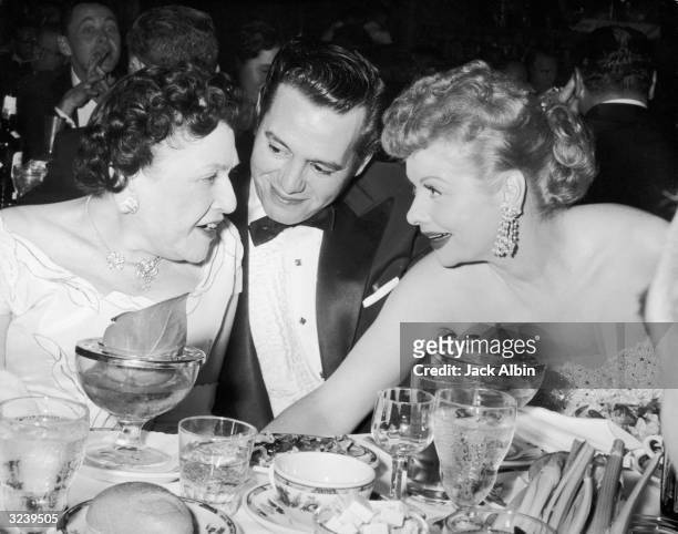 Married actors Desi Arnaz and Lucille Ball , chat with Hollywood gossip columnist Louella Parsons at the Golden Globe Awards, given by the Hollywood...
