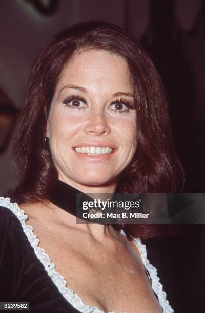 Headshot of American actor Mary Tyler Moore smiling at a party at Chasen's nightclub, Hollywood, California. She is wearing a low-cut black top with...