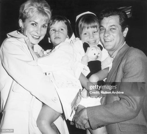 Married American actors Janet Leigh and Tony Curtis holding their daughters Kelly and Jamie prior to their departure on the SS 'Argentina,' bound for...