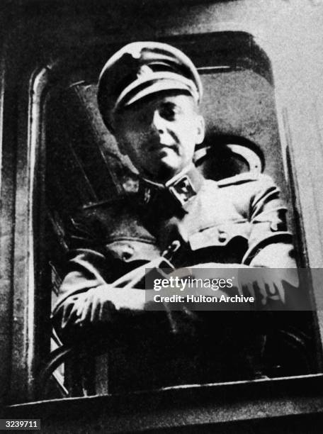 German Nazi doctor and war criminal Josef Mengele standing at a train window his SS uniform.